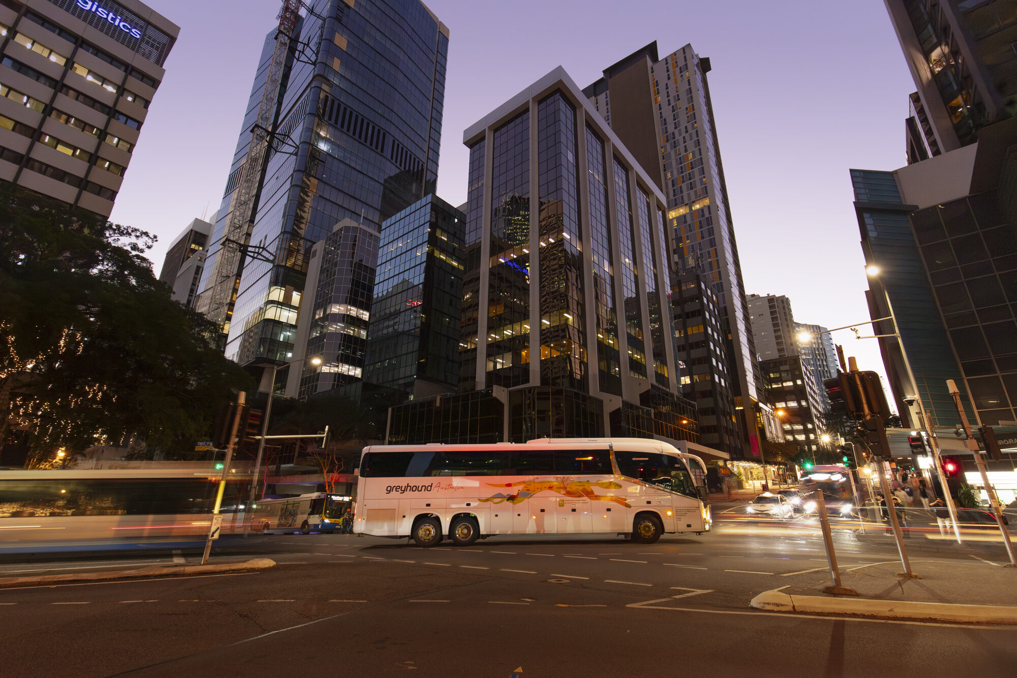 Greyhound coach cruising the Gold Coast with the city skyline and beach behind