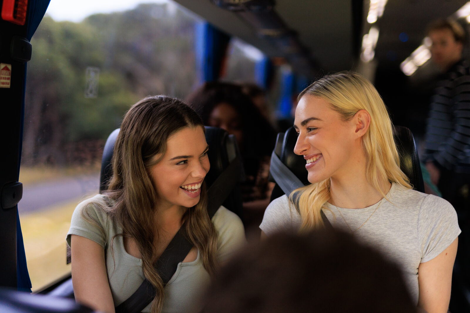 Two friends laughing together onboard a Greyhound coach