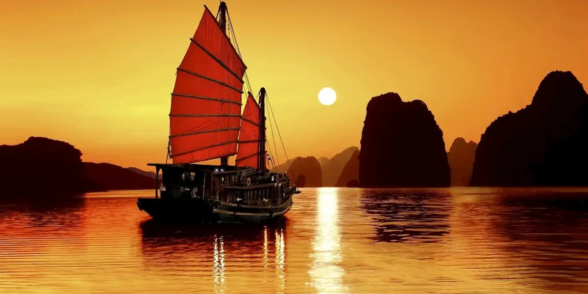 Vietnam Intro 12 days tour boat sailing at sunset in Vietnam waters