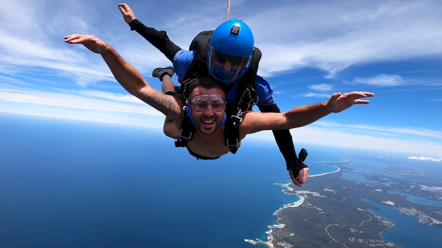 Tandem skydiver descending above Wollongong town and coastline