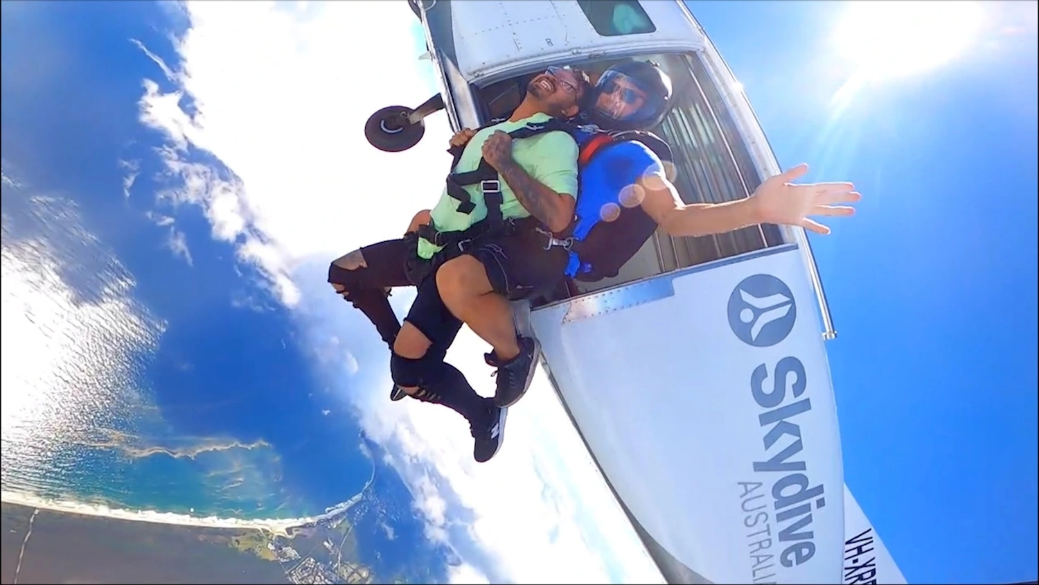 Tandem skydive jump from plane over Byron Bay coastline Australia