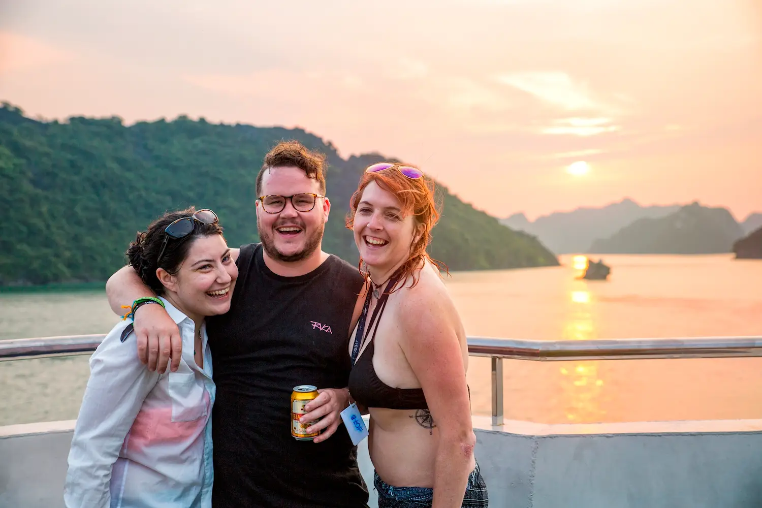 Group of young travellers enjoying sunset on a Ha Long Bay boat during a Vietnam and Cambodia 21 day tour