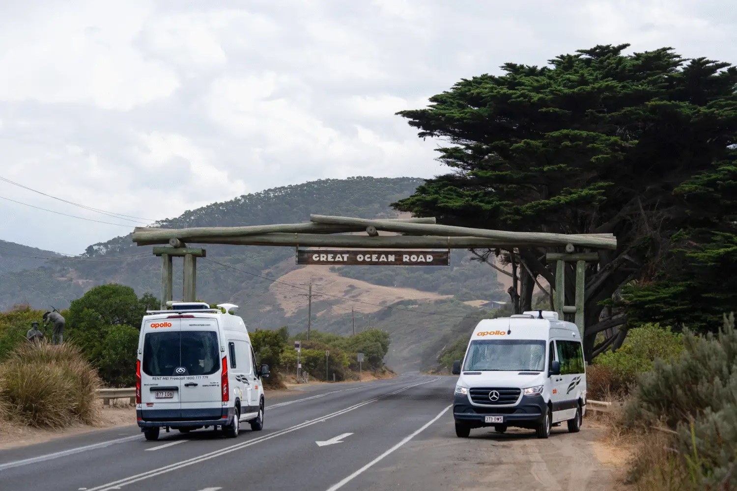 Apollo campervans driving under Great Ocean Road sign Victoria - campervan hire Melbourne