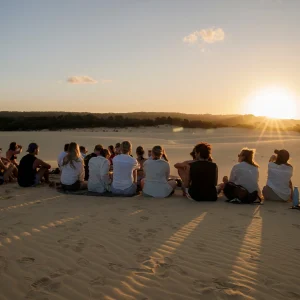 Group sitting on sand dunes watching sunset on Fraser Island