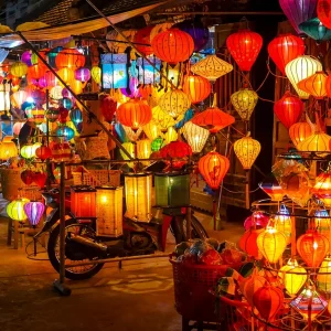 Hoi An, Vietnam - September 15, 2014: Street shops selling lanterns in a street market in Hoi An, Vietnam. People can be seen looking through the shops.
