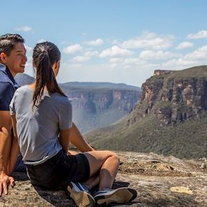 Couple enjoying views of the Grose Valley, Blackheath along the Grand Canyon Walking Track in the Blue Mountains.