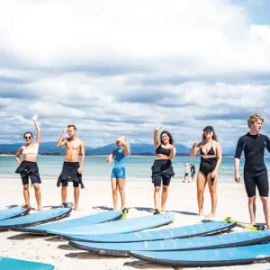 Backpacker surfing at sunrise on Australia’s East Coast during the Brisbane to Sydney Surf Bus tour