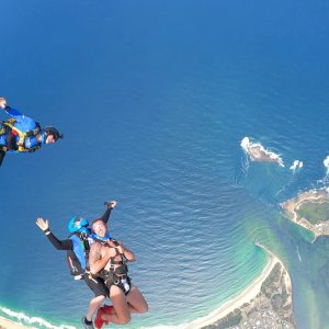 Tandem skydivers freefalling above Wollongong beaches and ocean