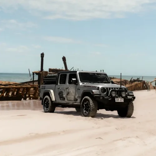 Couple driving a 4WD along Fraser Island’s 75 Mile Beach during an Australian adventure tour.
