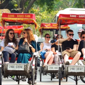 Group exploring Hanoi old quarter by cyclo rickshaw