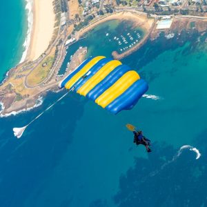 Parachute canopy open above Wollongong harbour and coastline