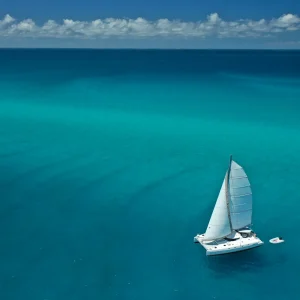 Sailing Catamaran O'Nice cruising through the turquoise waters of the Whitsunday Islands near Airlie Beach