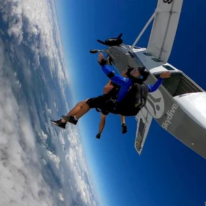 Tandem skydivers in freefall above clouds near Byron Bay Australia