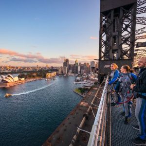 Friends enjoying a twilight BridgeClimb Sydney experience overlooking Sydney Harbour.